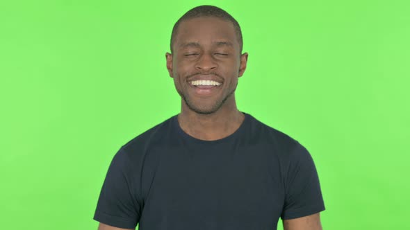 Young African Man Smiling on Green Background