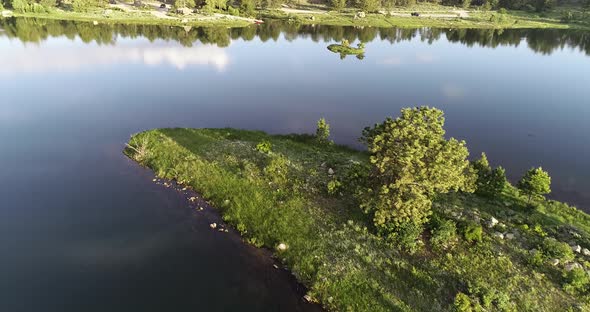 An early morning fly over of a Colorado lake taken by drone in 4k 60fps.  Beautiful reflections in t