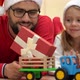 Father Gives Child Gift Next to Christmas Tree - VideoHive Item for Sale