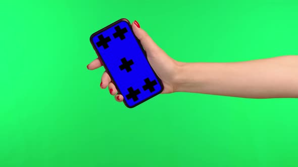 A Girl Holds a Smartphone with a Blue Chromakey on a Green Background