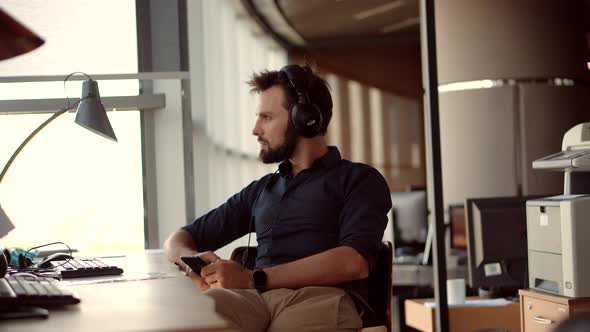 Happy Healthy Stress Free Man Relaxing In Office And Listening To Music. Employee Taking Break.