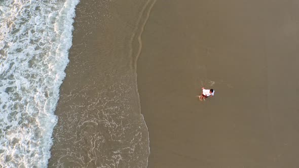 Aerial shot of young man running on the beach.