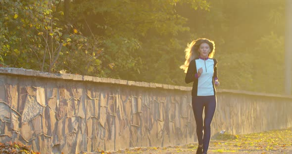 Woman Running in the Sunny City Park. Morning Light.