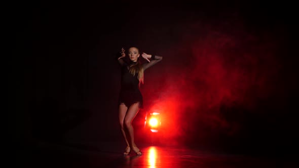 Dancer in Studio with Red Illumination on a Dark Background