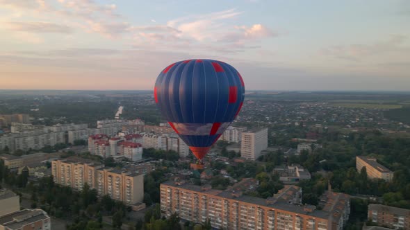 Colorful Hot Air Balloons Flying Over Green Park and Buildings in Small European City at Summer