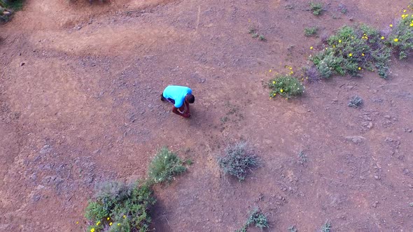 Aerial shot of a young man trail running on a scenic hiking trail.