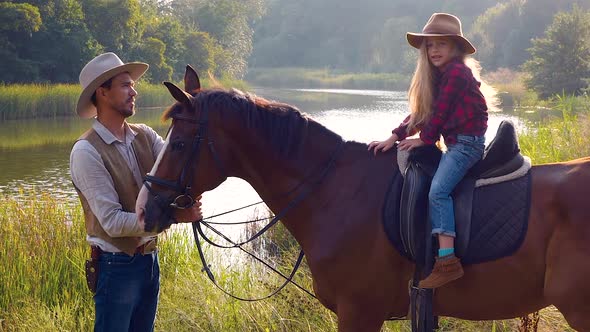 Cowboy and His Daughter on Horseback