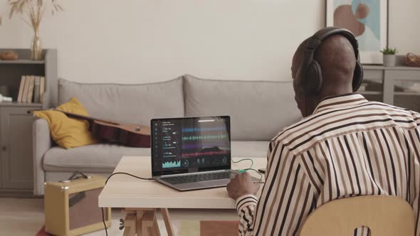 African-American Male Musician Making Electronic Music on Laptop