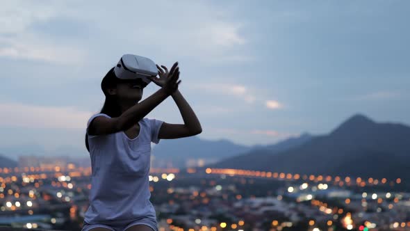 Woman uses a virtual reality glasses on the roof 