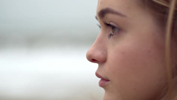 Closeup Portrait in Profile of Concentrated Woman with Eye Makeup Looking Into Distance Thinking