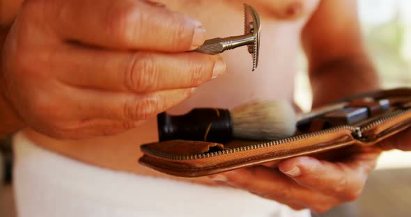 Mid-section of man holding shaving kit 4k