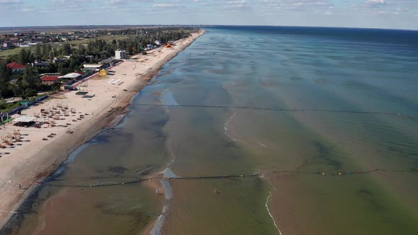 Beautiful flight in summer over the beach. People are resting near the sea.