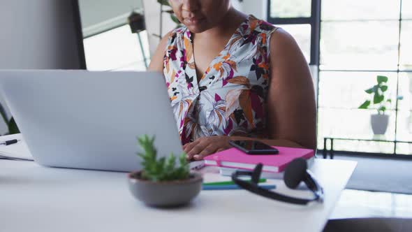 African american female plus size vlogger sitting using laptop