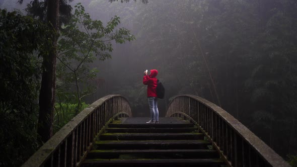 Traveler taking picture of rainy forest