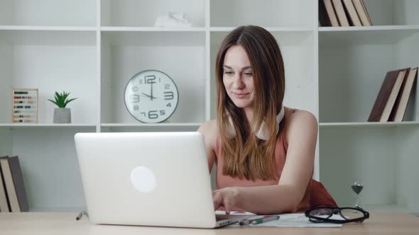 Happy Young Woman Laughing at Funny Streaming Movie on Laptop or or is in Correspondence