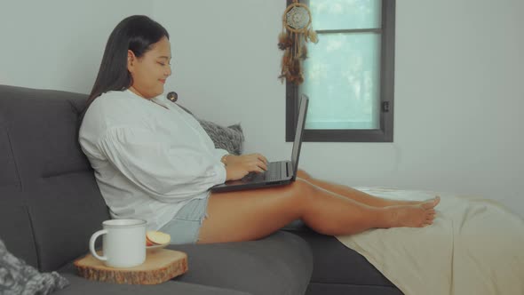 Asian Plus Size Woman Working Online with Laptop at Home