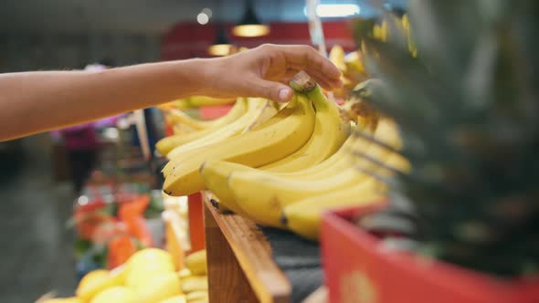 Young Woman Buying Yellow Bananas in Supermarket