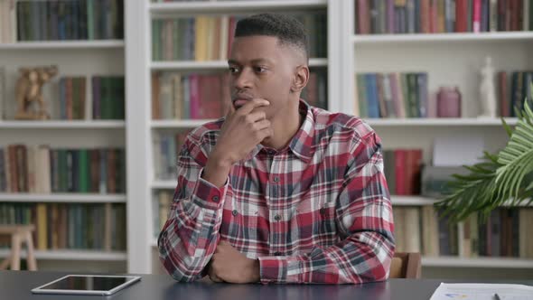 Pensive African Man Thinking While Sitting in Office