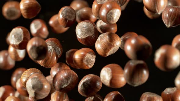 Super Slow Motion Closeup Shot of Flying Whole Hazelnuts Towards Camera on Black at 1000Fps