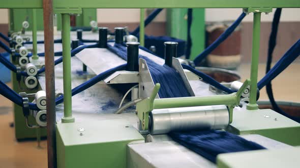 Pieces of Coloured Cloth are Moving Through the Conveyor