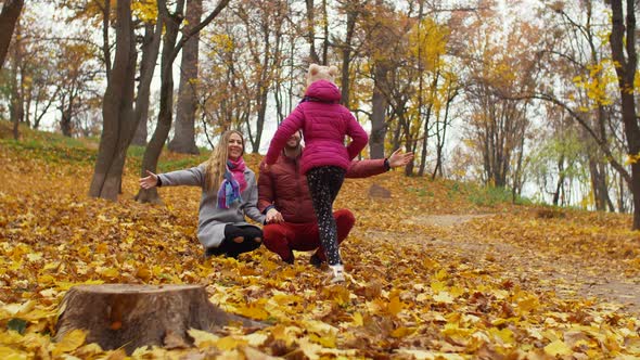 Loving Parents Embracing Little Daughter in Autumn