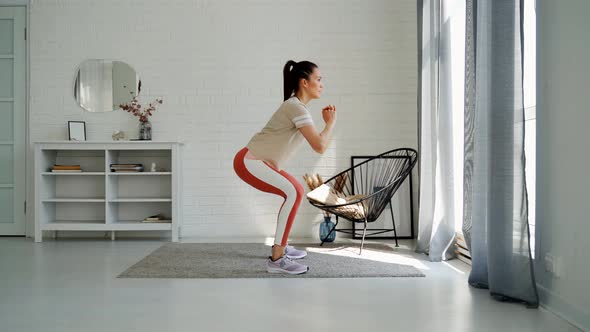Sporty Fitness Woman Doing Squat Workout at Home