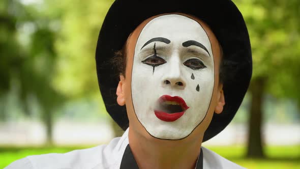 Mime in a Black Hat Smokes Outdoors. Bad Habits