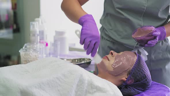 Cosmetologist Applying Facial Mask to the Face