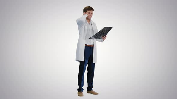 Shocked Male Doctor Looking at Computed Tomography of the Brain on Gradient Background