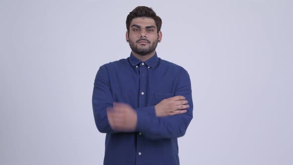 Happy Young Bearded Indian Businessman Smiling with Arms Crossed