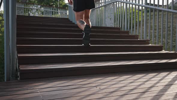 Sportive Athlete Runs Fast on Wooden Stairs on Sunny Day