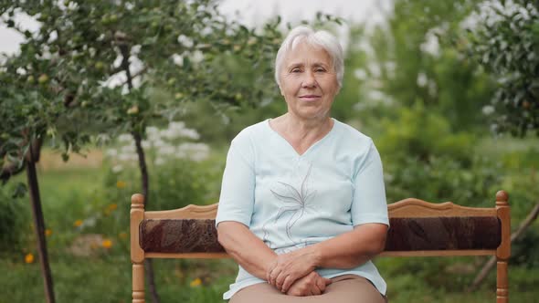 Elderly Woman Sitting on A Bench in The Garden