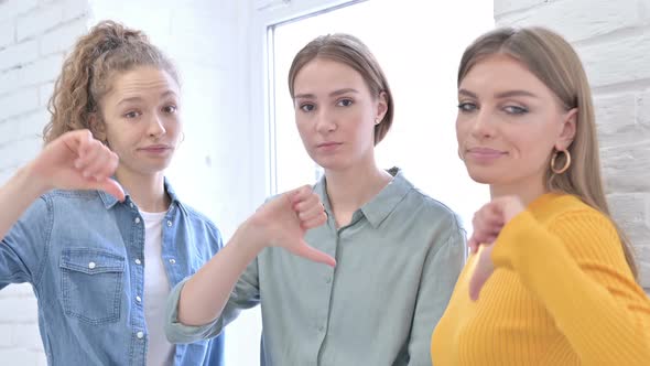 Disappointed Female Creative Team Showing Thumbs Down