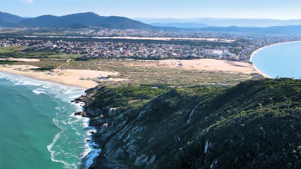 Aerial drone scene of urbanized paradise beach with sand dunes, mountains and sea beach of santinho