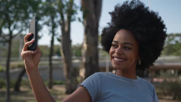 Mixed race woman taking pictures in park