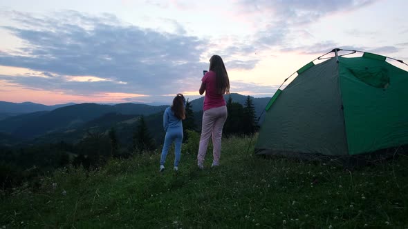 Two Girls Girlfriends are Resting in the Alps They are Having Fun