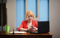 Redhead businesswoman using laptop and smartphone at the office - PhotoDune Item for Sale