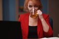 Businesswoman drinking tea while working on laptop at the office - PhotoDune Item for Sale