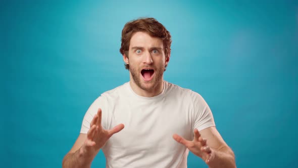 Frightened Screaming Young Man Afraid of Something Blue Background