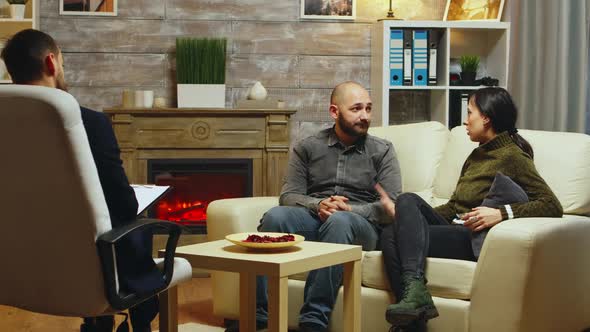 Couple Sitting on Couch Arguing with Each Other