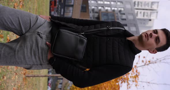 Man Walking with Messenger Bag in an Autumn City Vertical Video