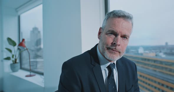 Close up of a businessman with blue eyes looking straight to the camera