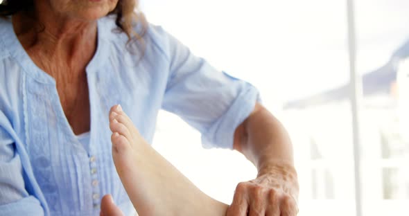 Woman therapist massaging the feet of her patient