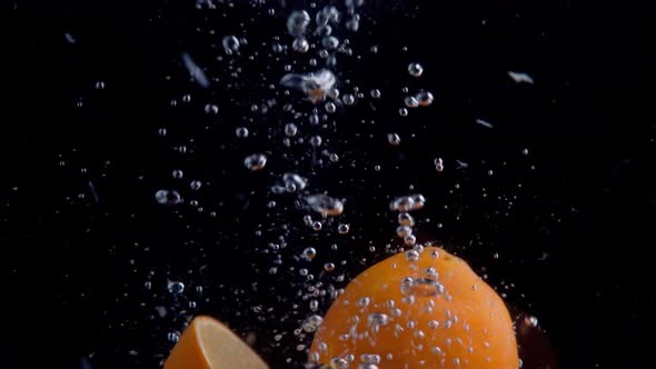 Oranges Falling into Water Super Slowmotion, Black Background, lots of Air Bubbles, 4k240fps