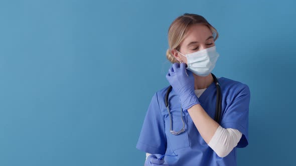 Tired doctor takes off glasses, protective mask while taking a deep breath