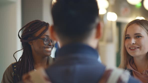 Diverse University Students Talking and Smiling Standing in College Corridor