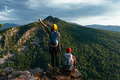 A traveling couple in hiking gear in the mountains at sunset. Two travelers - PhotoDune Item for Sale