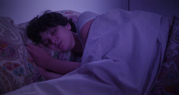 Young woman sleeping at home in bed