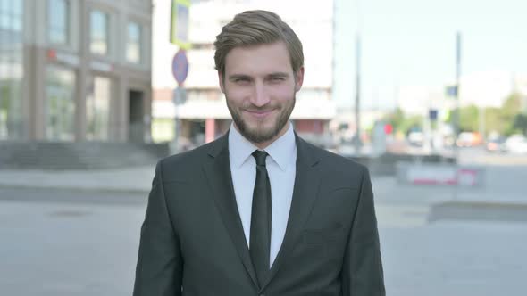 Portrait of Agree Businessman Shaking Head in Approval Outdoor