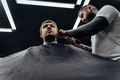 Male haircut with electric razor. Tattooed Barber makes haircut for client at the barber shop by - PhotoDune Item for Sale
